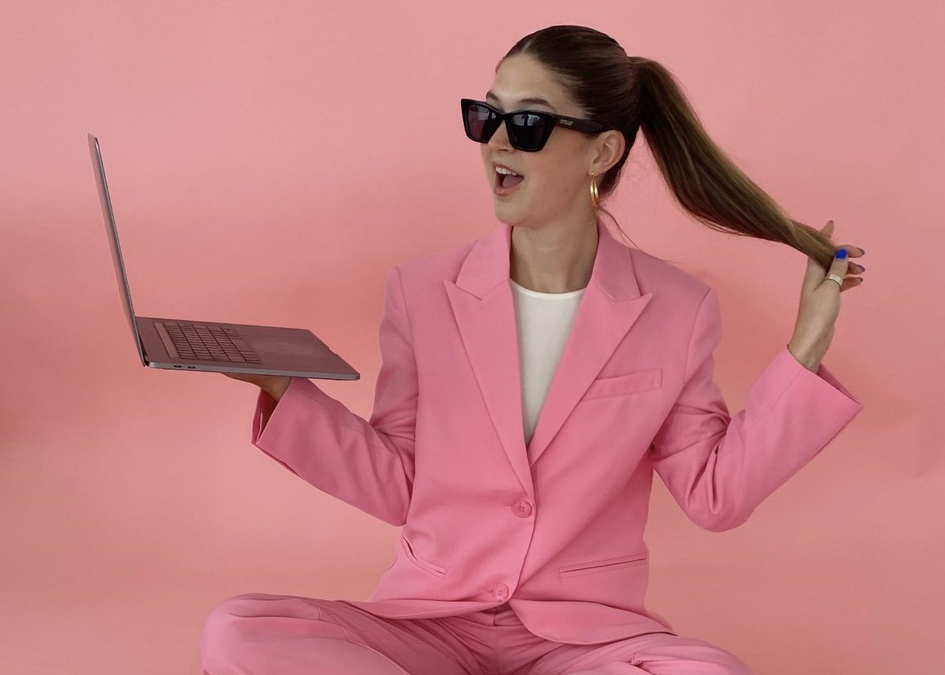 business woman with pink background and laptop