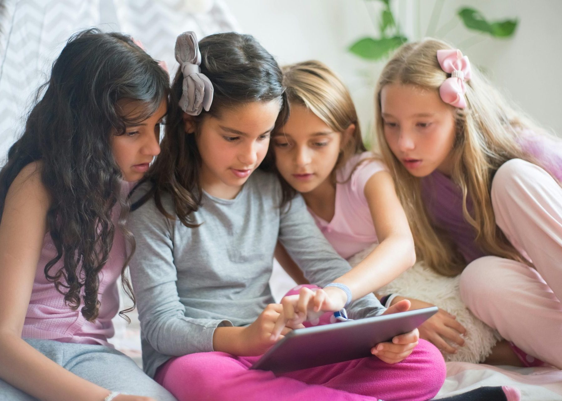 4 female children (gen alpha) looking at tablet