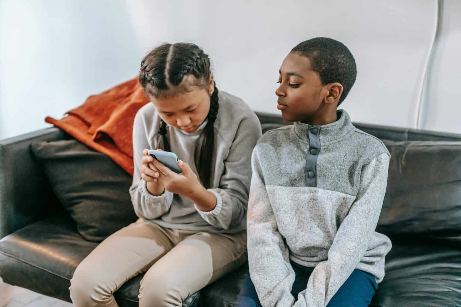 two children looking at phone