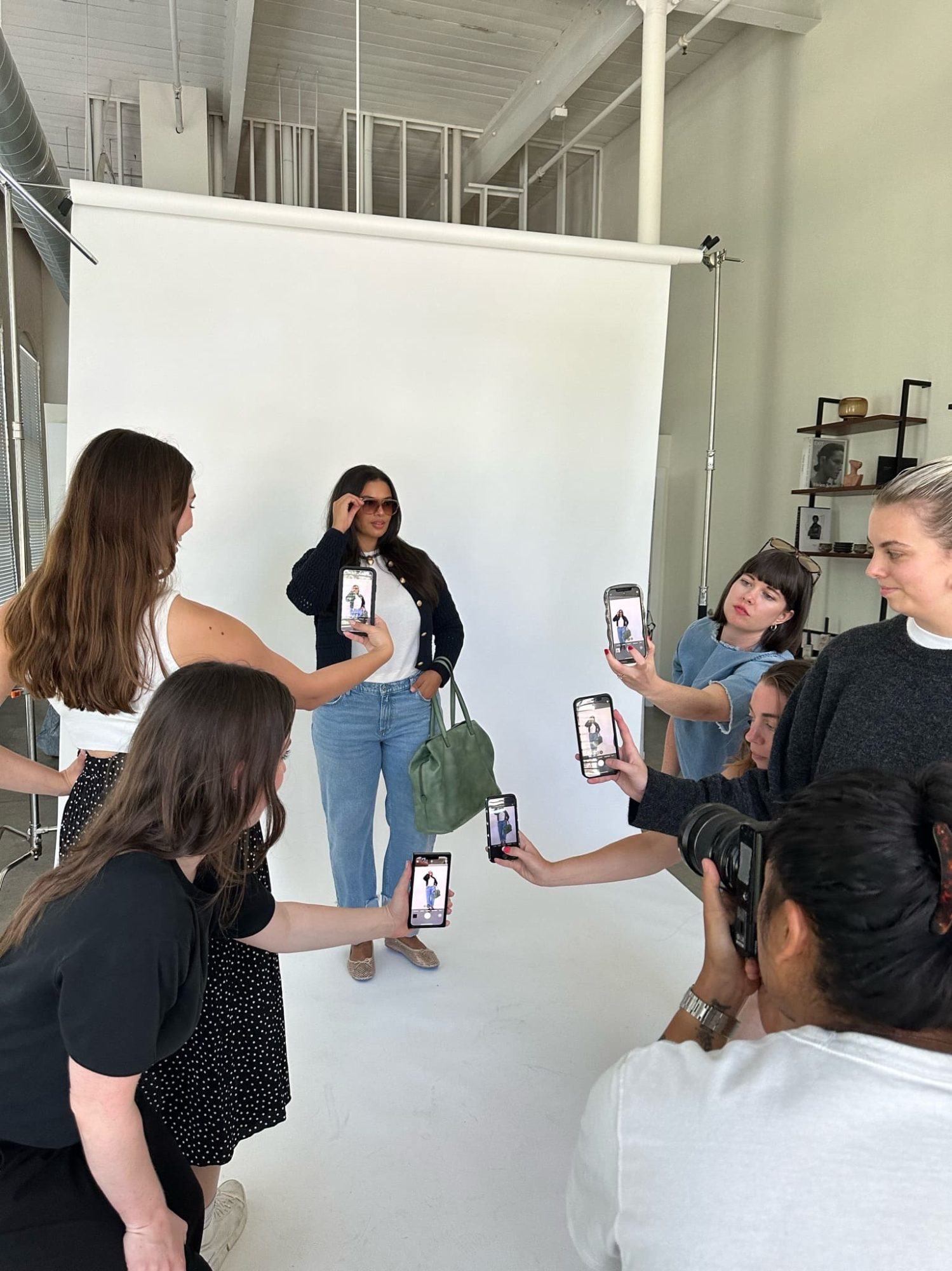 woman being photographed by multiple people during a shoot