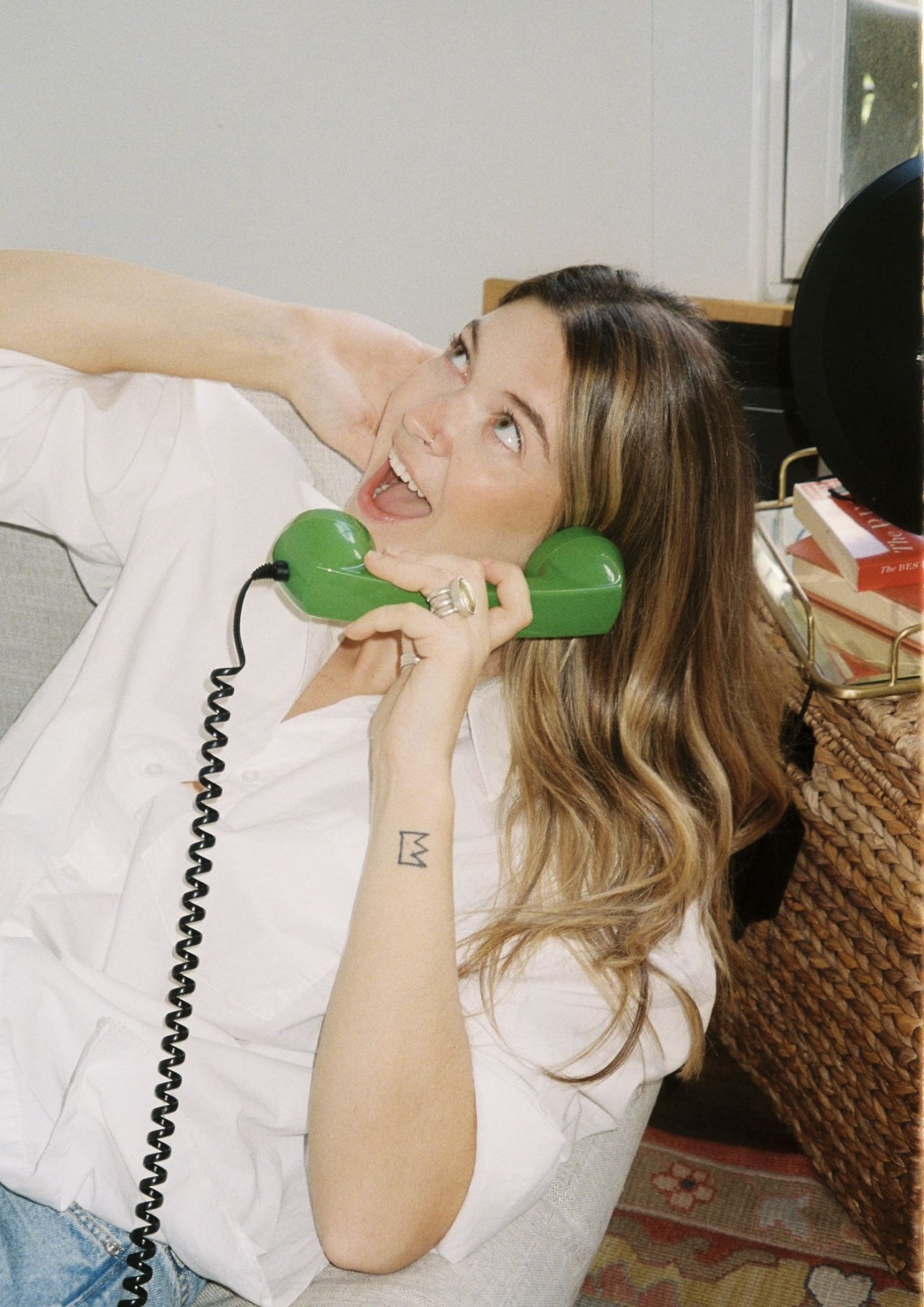 woman posing in front of camera with green phone