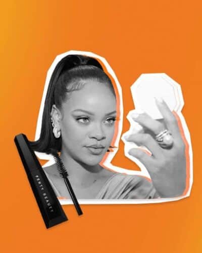 Rhianna Looking Into Fenty Makeup Mirror With Fenty Mascara Next To Her