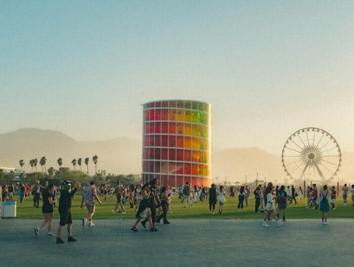 The Coachella Festival At Sunset Showing People Walking Around And The Iconic Ferris Wheel.